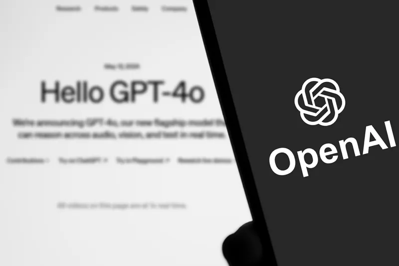 گوشی هوشمندی که لوگوی OpenAI را با تصویری مبهم از سندی که انتشار GPT-40 را در پس‌زمینه اعلام می‌کند نمایش می‌دهد.