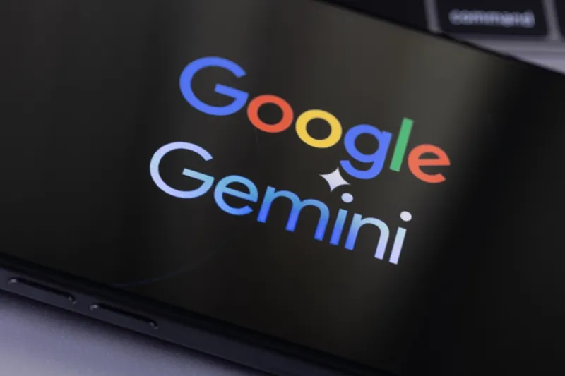 یک صفحه نمایش هوشمند که Google Gemini را با حروف جسورانه و رنگارنگ در پس زمینه تاریک نشان می دهد.